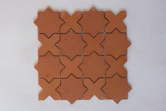 Terracotta tiles with star-and-cross shaped cutouts on a white background