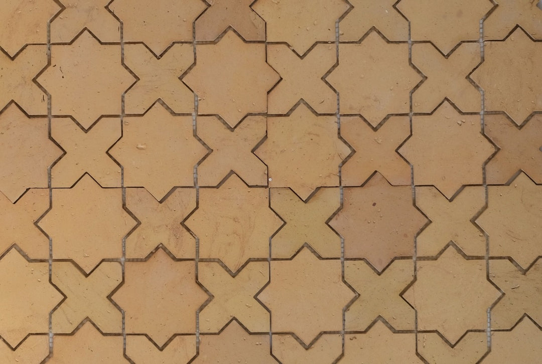 Pattern of star-and-cross shaped tiles in a grid on a beige background