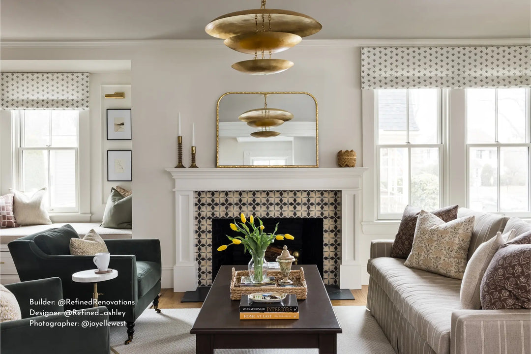 Sophisticated living room with a statement geometric tile fireplace, brass chandelier, tailored seating, and layered neutral textures.