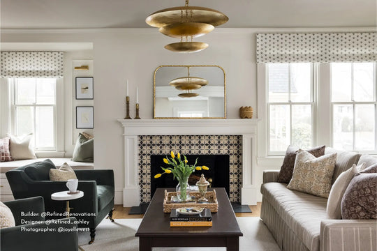 Sophisticated living room with a statement geometric tile fireplace, brass chandelier, tailored seating, and layered neutral textures.