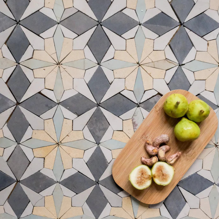 Wooden cutting board with fruits on a floral tile patterned surface