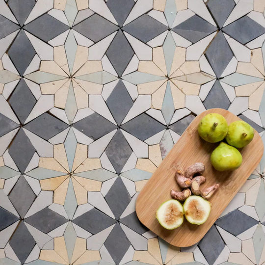Wooden cutting board with fruits on a floral tile patterned surface